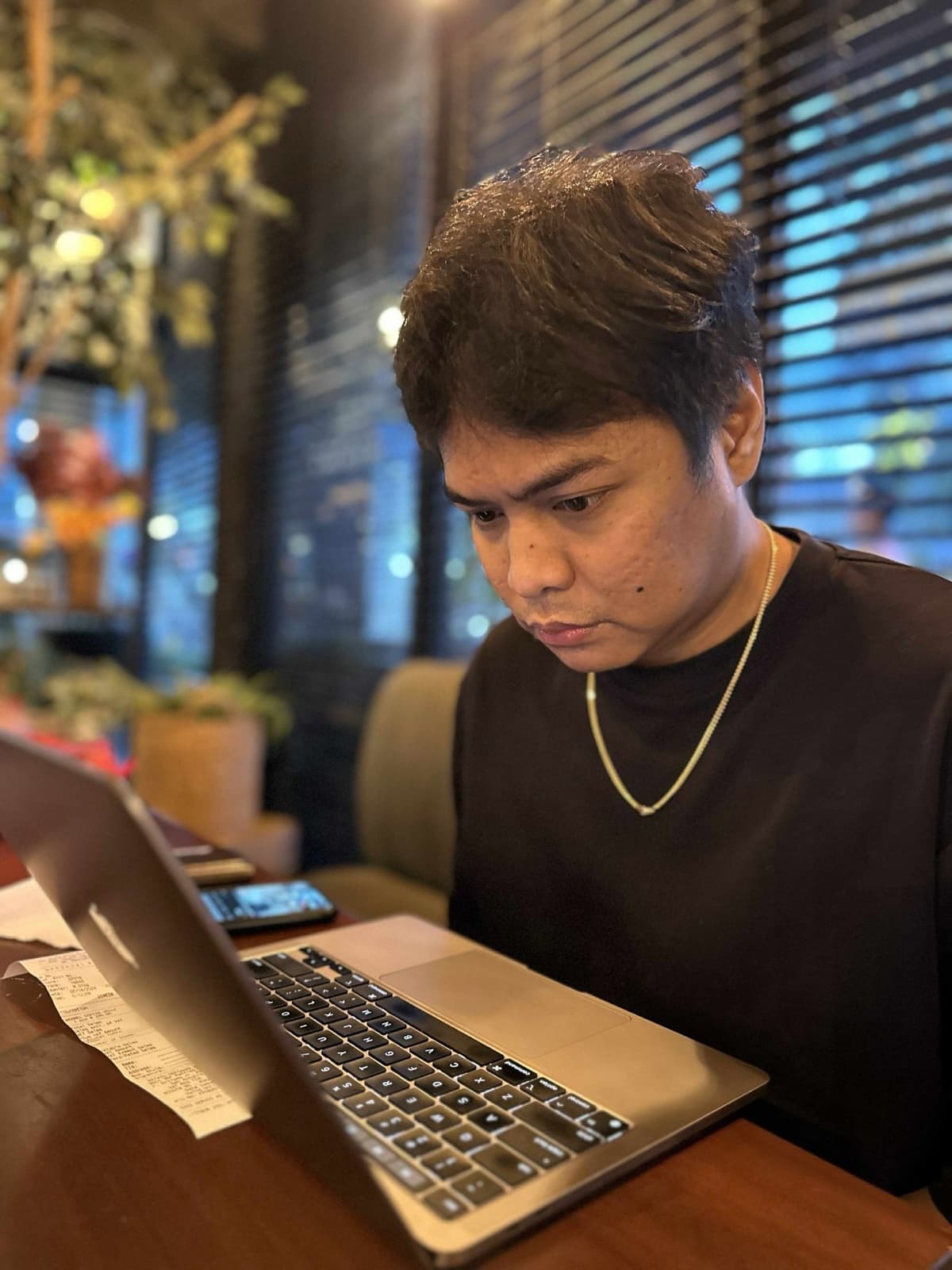 Mark Tingson working on his laptop at a café